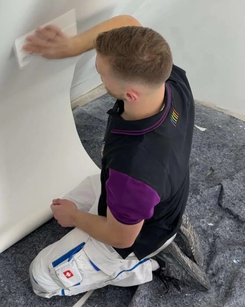 Pepe Strube, Polier bei Capital Color, beim Tapezieren einer Wand